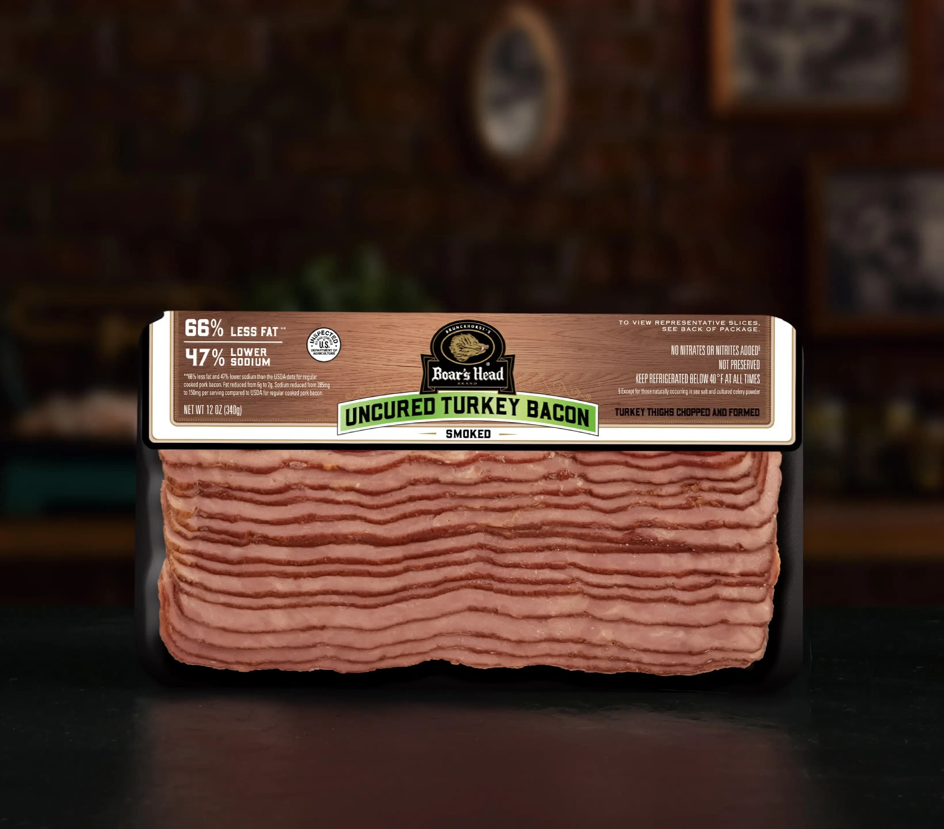 A package of the Boar's Head® Uncured Turkey Bacon sits on a countertop, in the foreground of a red brick wall.