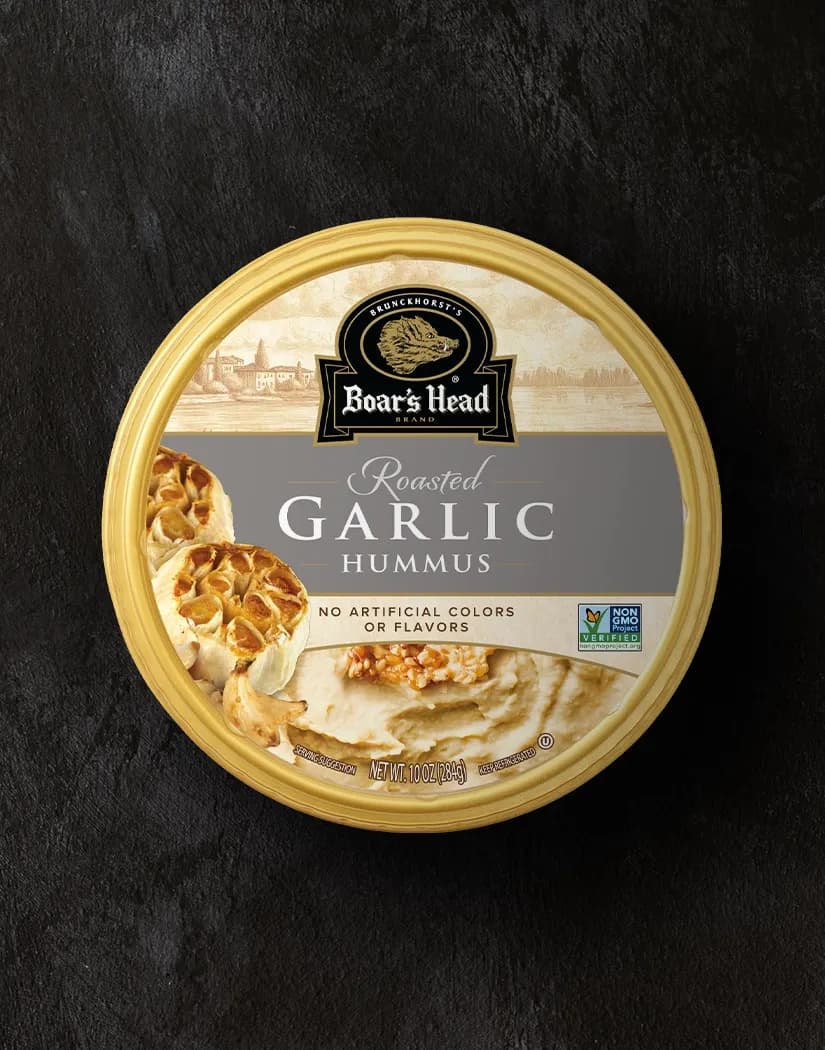 An aerial view of the Boar's Head® Garlic Hummus that sits on a graphite colored background.