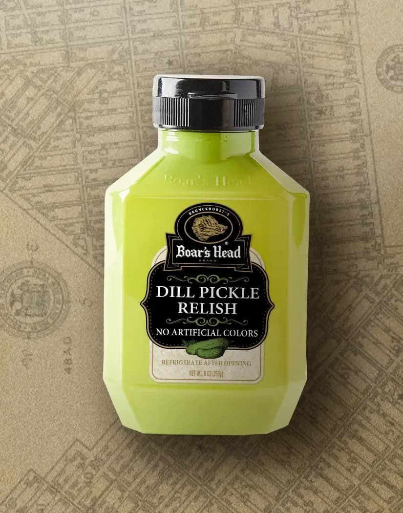 A container of Boar's Head® Dill Pickle Relish sits on a tan illustrated image of New York City.