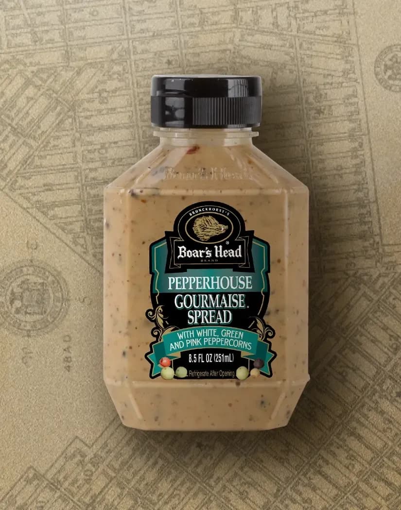 The Boar's Head® Pepperhouse Gourmaise® Spread sits on a tan illustrated image of New York City.