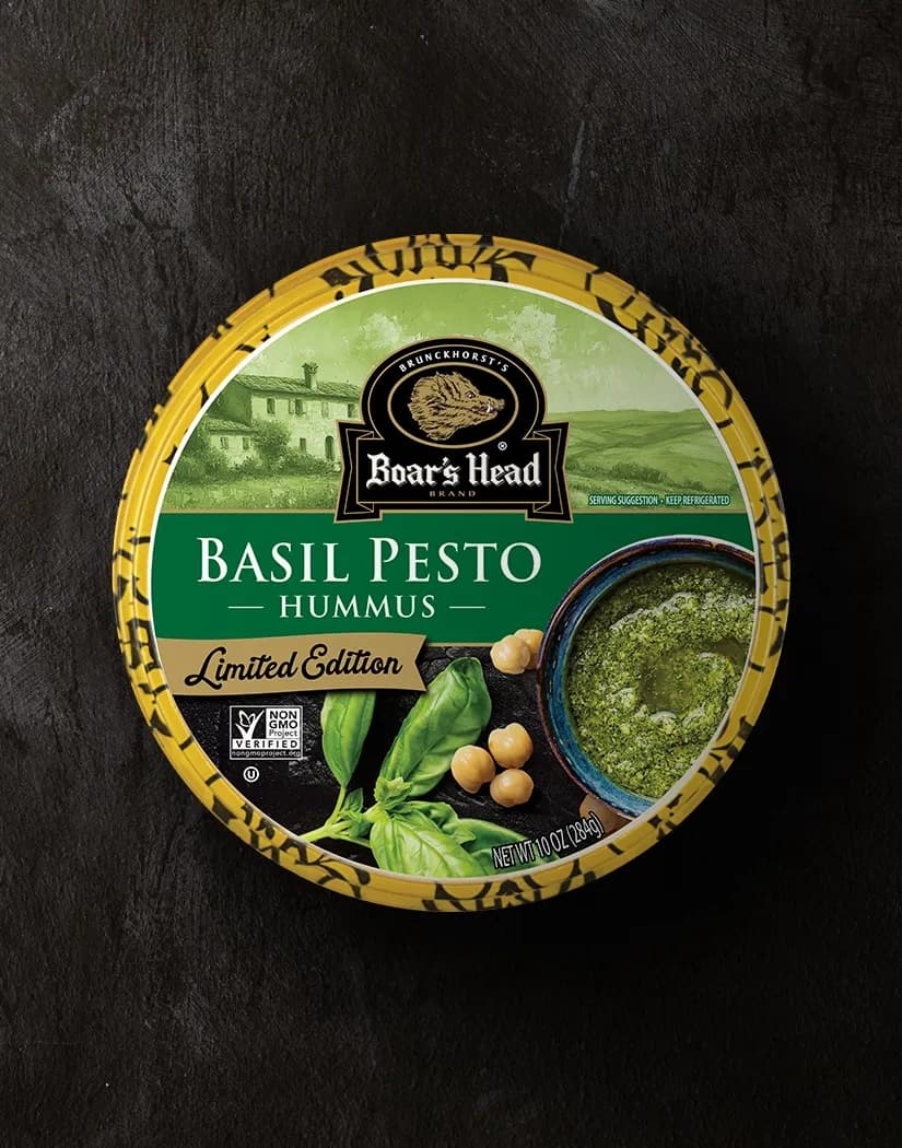 An aerial view of the Boar's Head® Basil Pesto Hummus that sits on a graphite colored background.